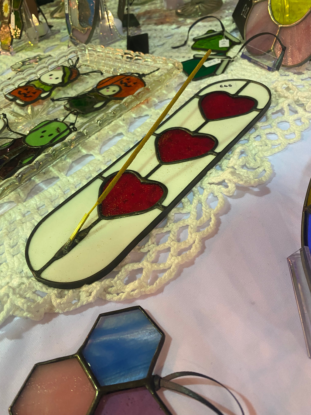 Decorative stained glass panel with red hearts on a white background