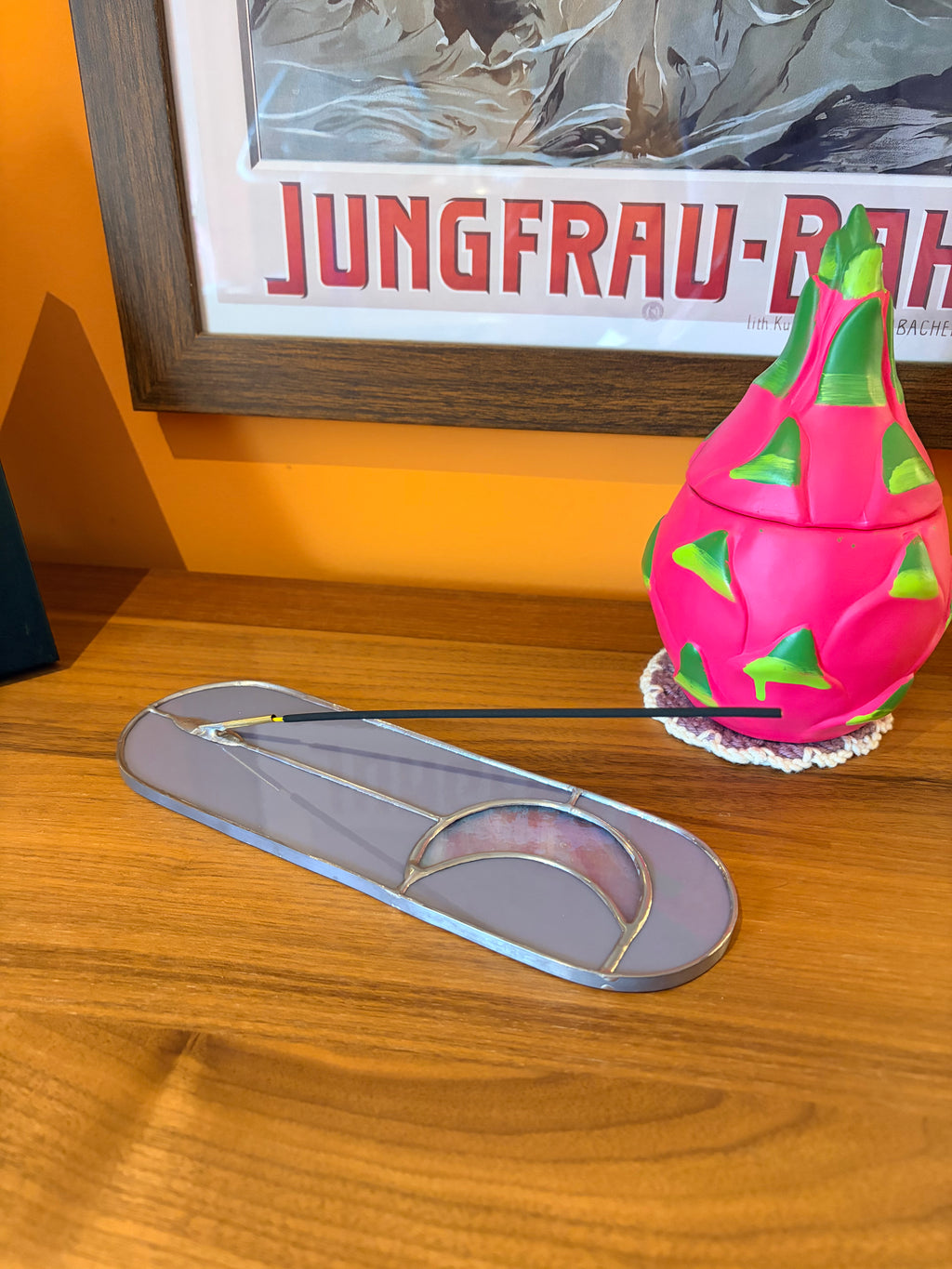 A purple and pink incense stick holder with an iridescent moon
