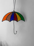 Colorful stained glass umbrella hanging against a plain background