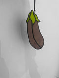 Stained glass suncatcher shaped like an eggplant or aubergine on a white background