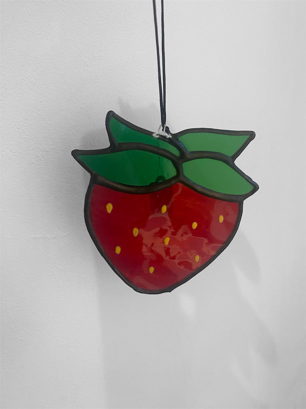Stained glass strawberry ornament on a white background
