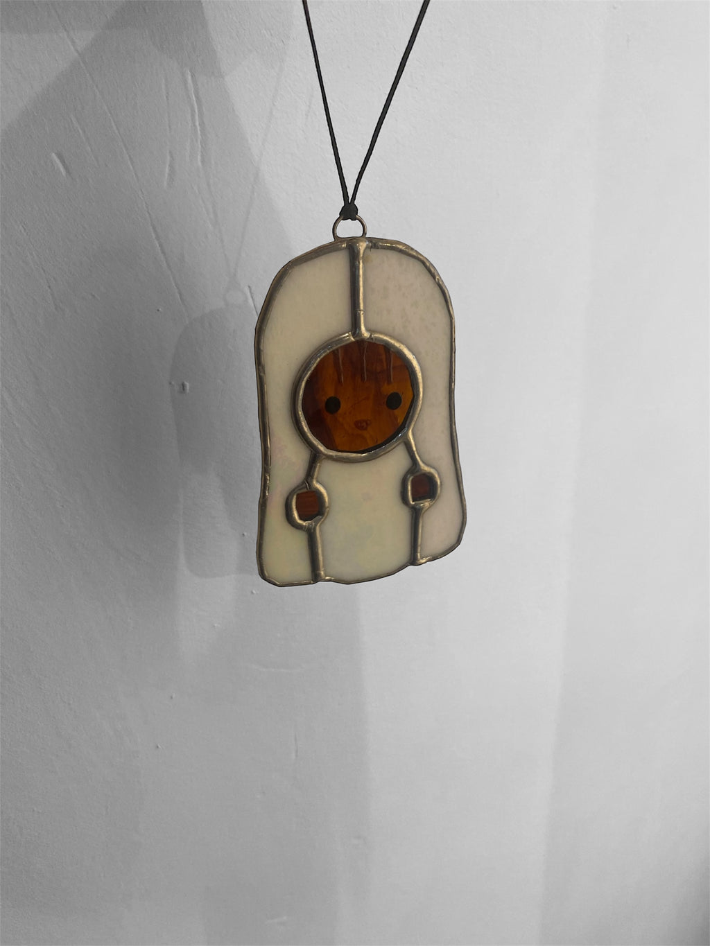 Kawaii-style squirrel character with a ghost costume stained glass ornament on a gray background