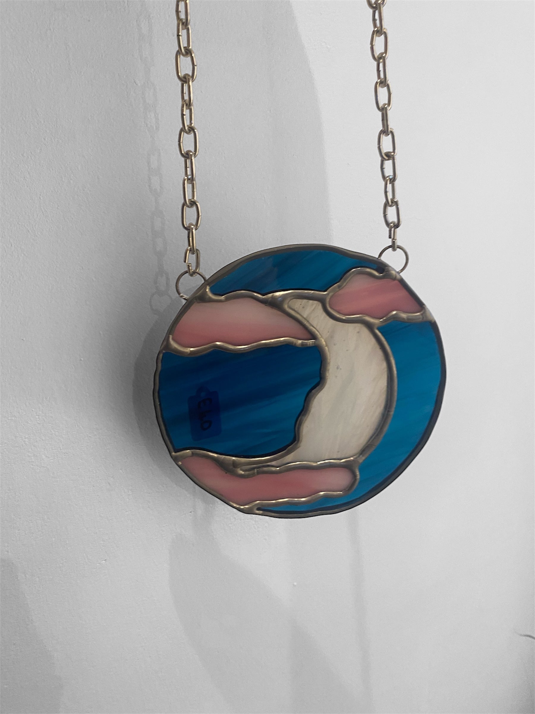 stained glass suncatcher with pink and dark blue glass, featuring a celestial moon in the clouds
