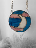 stained glass suncatcher with pink and dark blue glass, featuring a celestial moon in the clouds