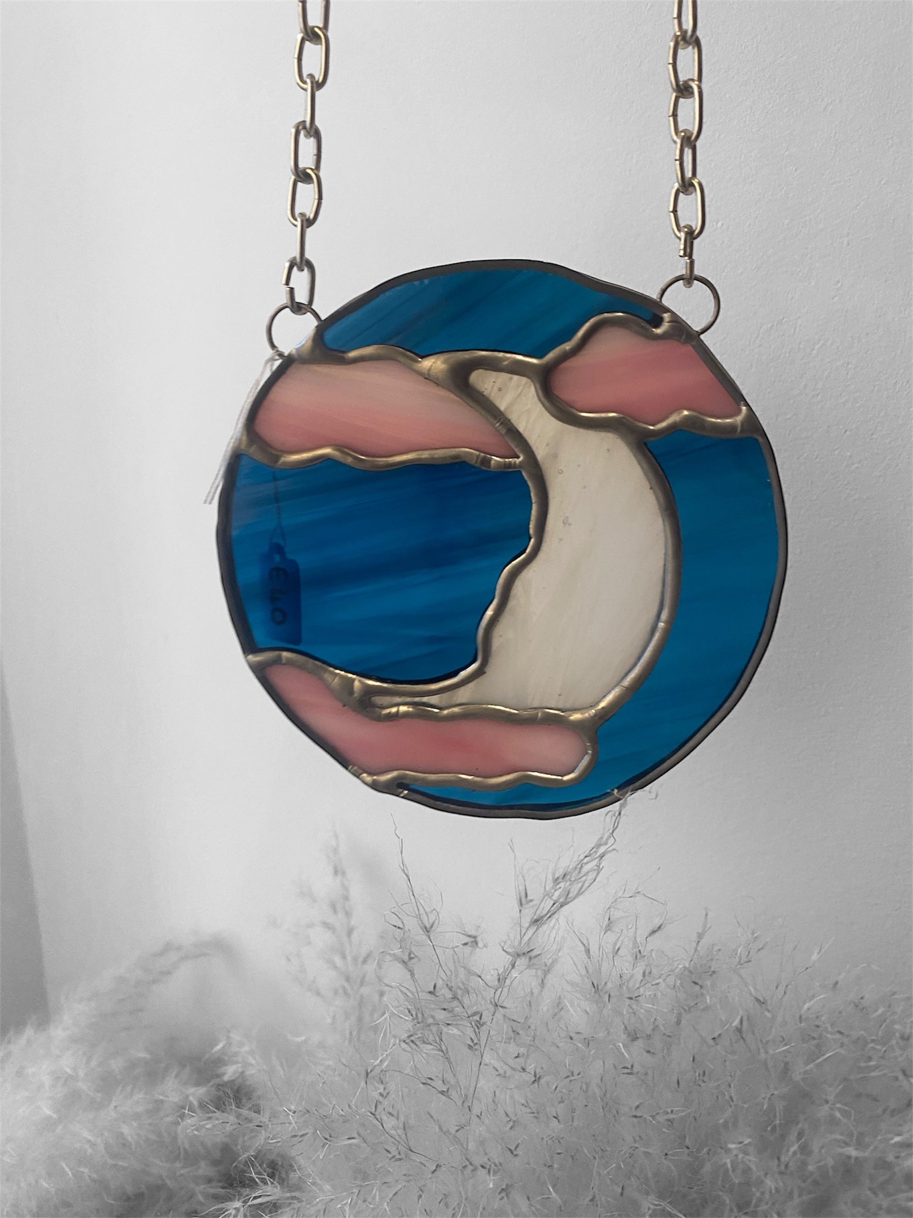 stained glass suncatcher with pink and dark blue glass, featuring a celestial moon in the clouds