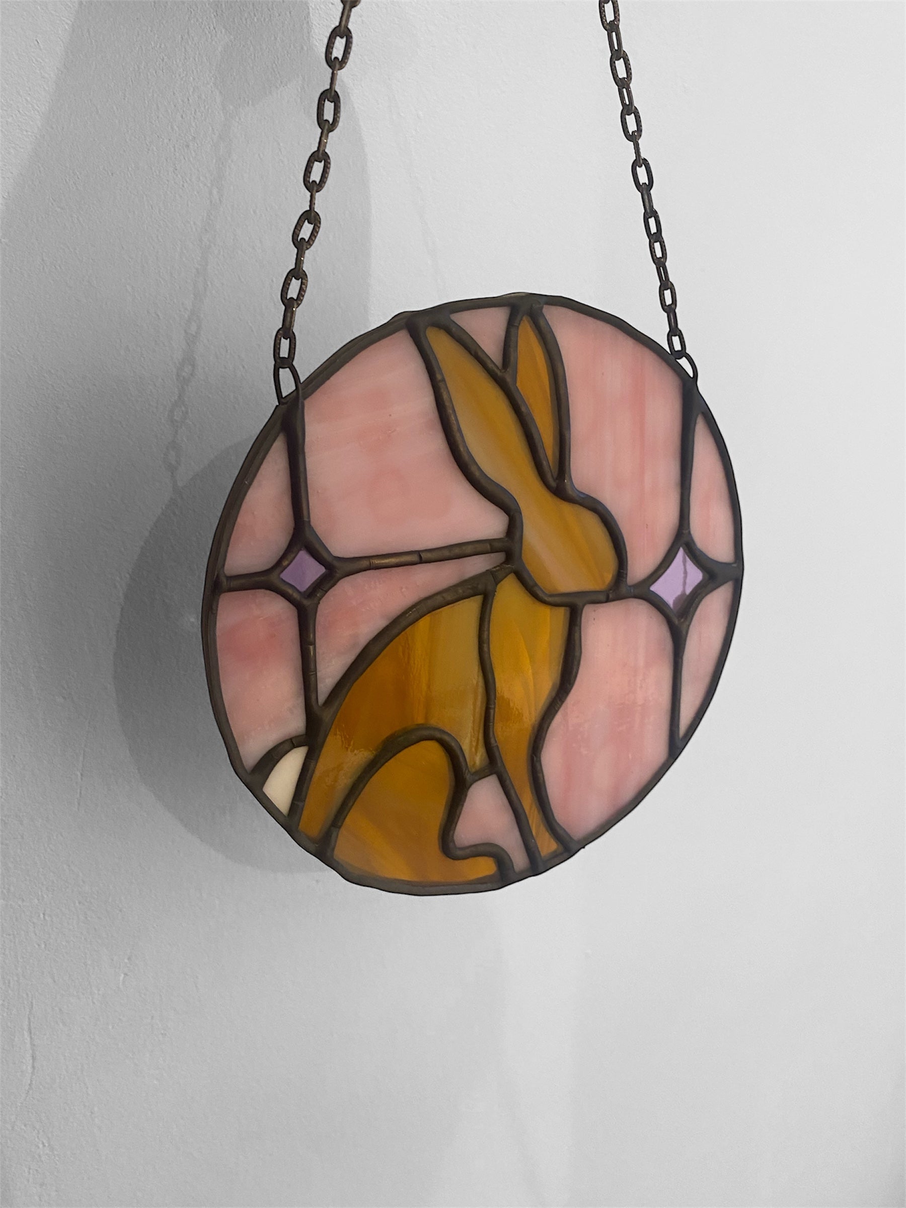 Stained glass suncatcher with a rabbit or hare design on a white background