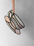 A pink iridescent glass teacup with a funny phrase painted on the side