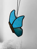 A blue stained glass butterfly with a bullet instead of a butterfly body