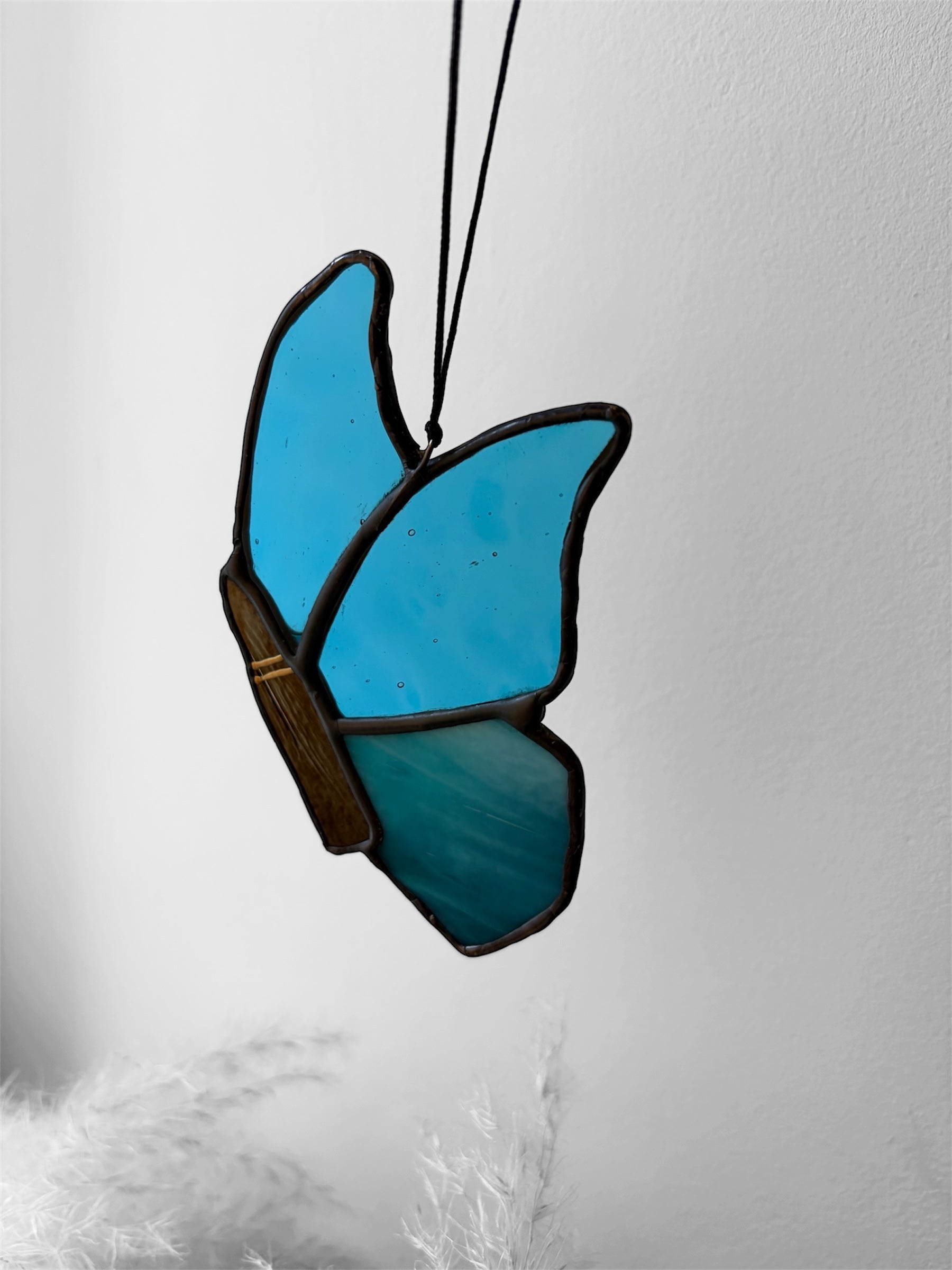 A blue stained glass butterfly with a bullet instead of a butterfly body