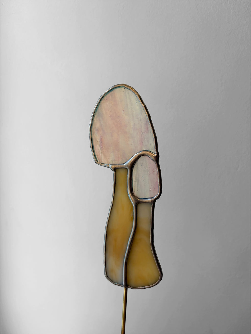 pink stained glass mushroom on a metal stake to decorate house plants