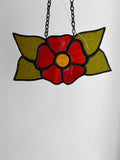Stained glass flower pendant on a chain against a white background