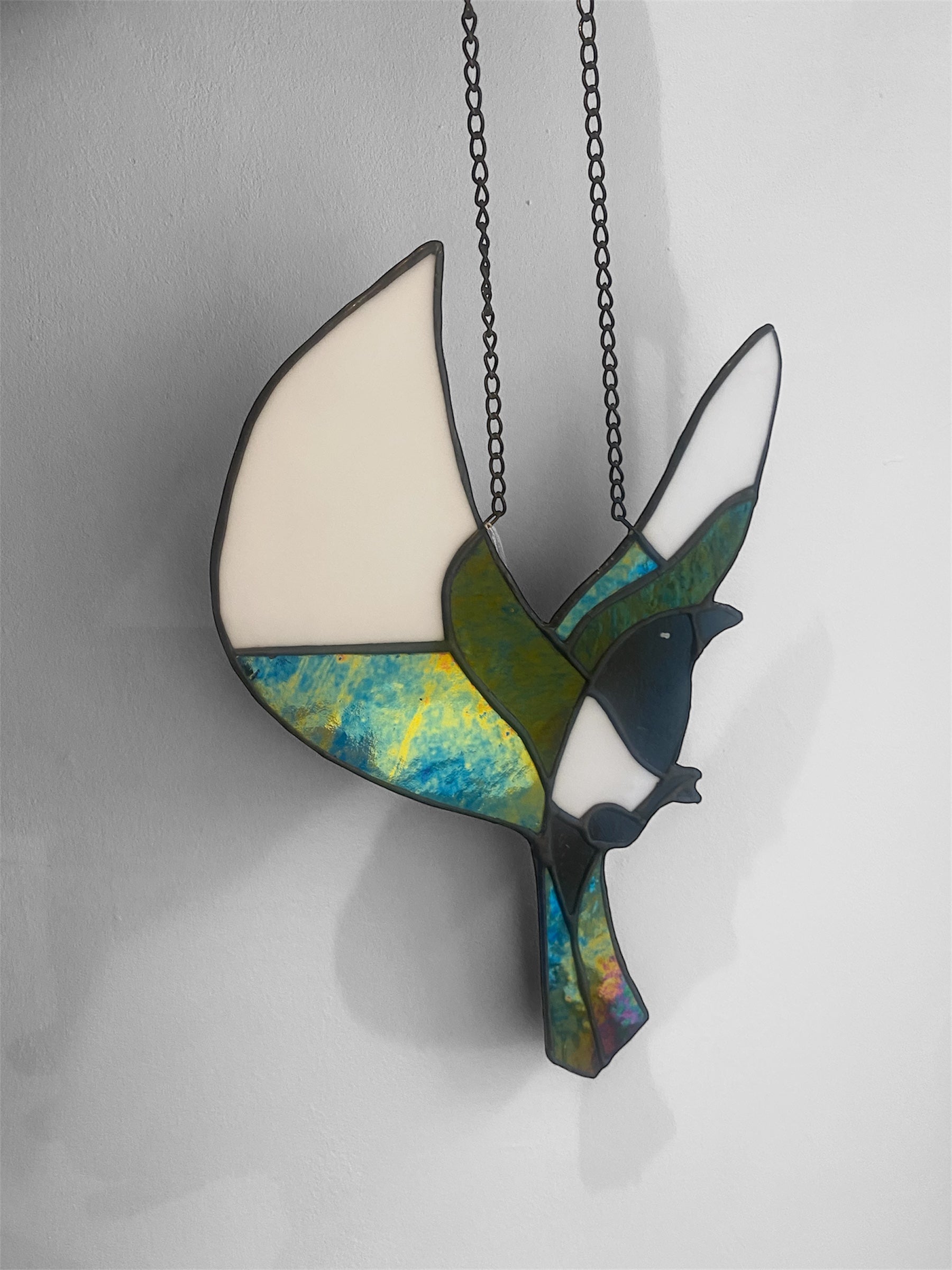 Stained glass magpie bird suncatcher with a chain on a white background