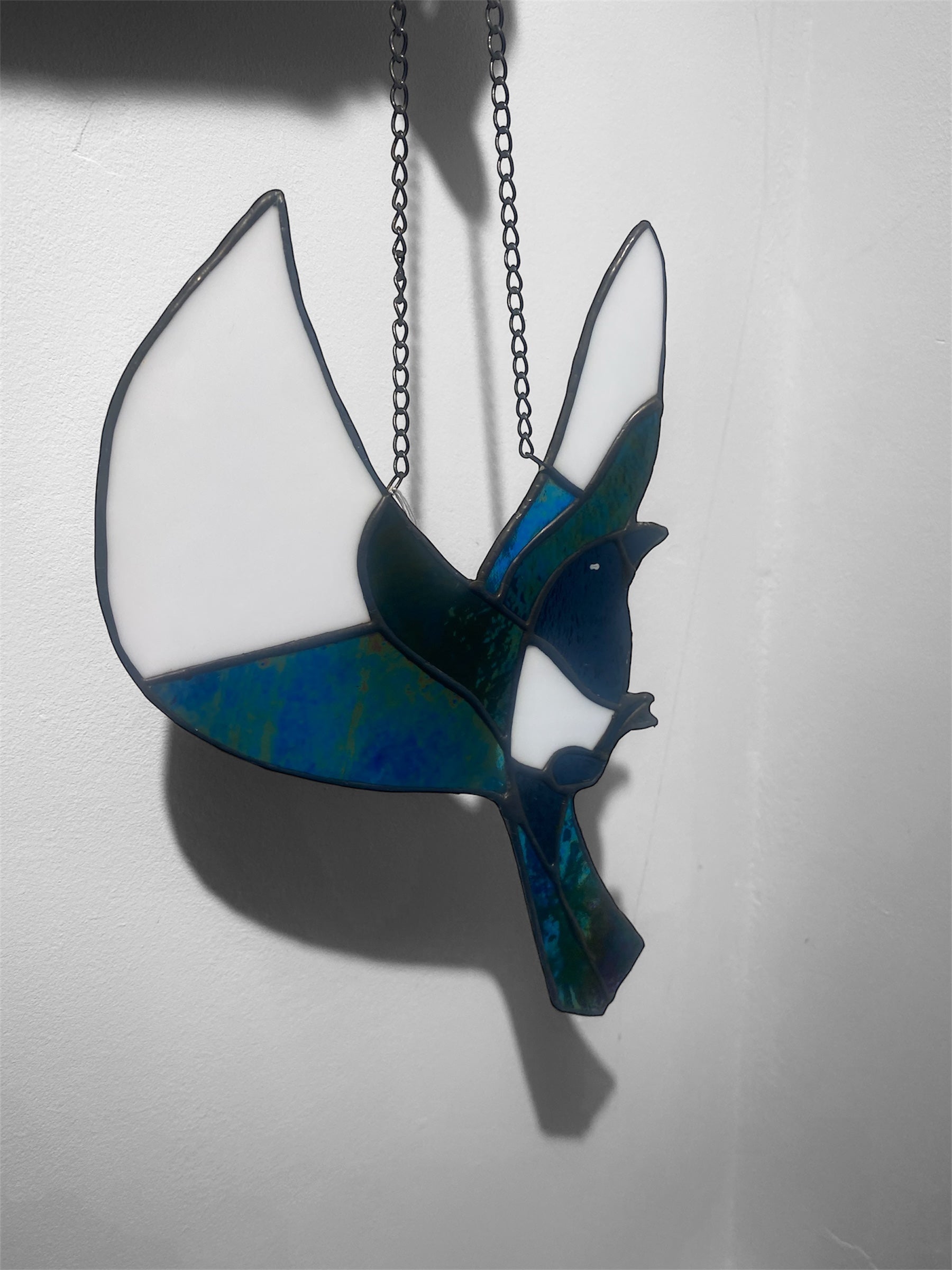 Stained glass magpie bird suncatcher with blue and green design on a white background