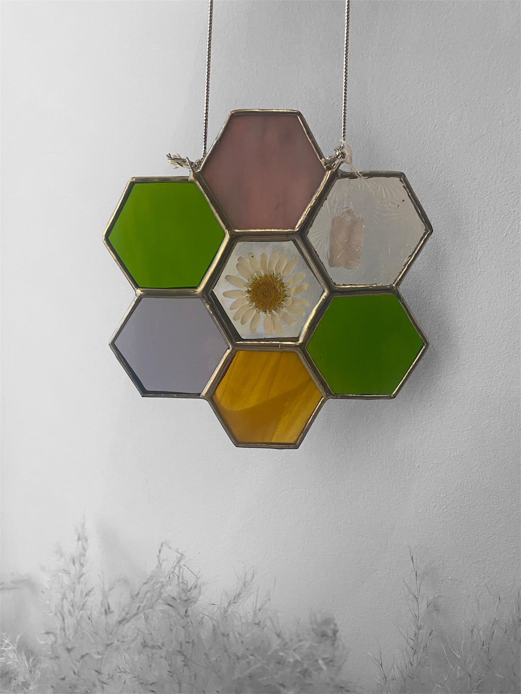 Hexagonal stained glass panel with a floral center on a white background
